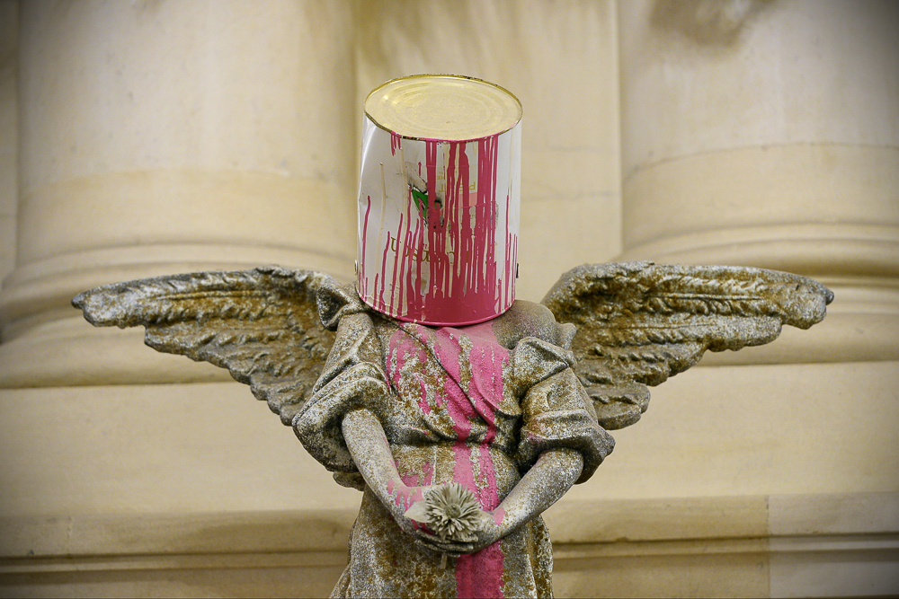 Angel sculpture with bucket of paint on its head