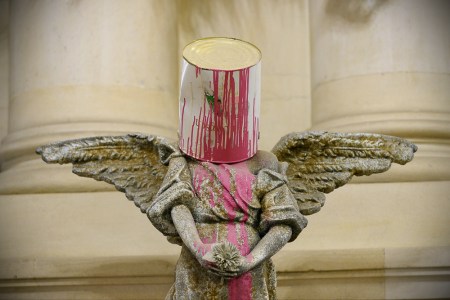 Angel sculpture with bucket of paint on its head