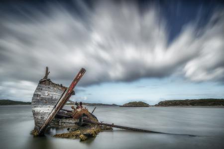 Ancient ship wreck on a sandy beach.