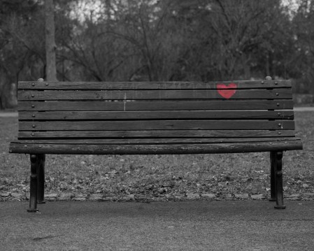 Park bench with a heart painting on the back.